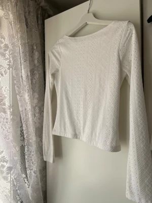 Vit långärmad spetsmönstrad topp - Säljer en vit långärmad topp med snyggt spetsmönster och rund hals. Materialet känns mjukt och luftigt, perfekt för dig som gillar en feminin och stilren look. Passar till både jeans och kjol för en fräsch outfit. Pris kan diskuteras 🥰