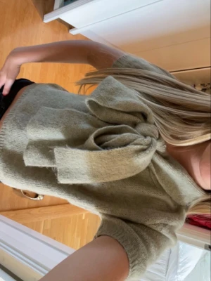Skit snygg unik tröja!!💓 - Snygg olivgrön stickad topp med korta ärmar och stor rosett framtill vid halsen. Tröjan är knappt andvänd och är i ett fint sick! Stolek XS💓