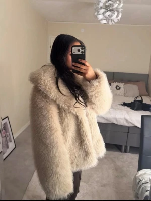 Pälsjacka Gina tricot  - Säljer en supermysig beige pälsjacka med bred krage och rak passform. Jackan är gjord av syntetpäls och har en lyxig, fluffig look som verkligen sticker ut. Perfekt för dig som vill ha en trendig och varm jacka till hösten och vintern. Originalpriset är 799, använd en gång 