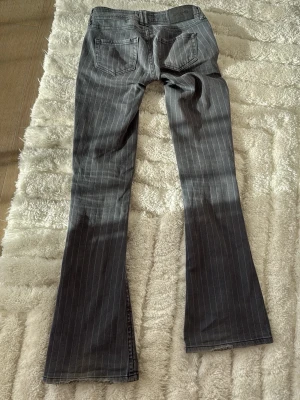 Unika Gråa bootcut jeans med ränder från BDG - PRIS KAN DISKUTERAS! ❤️🤗Snygga gråa bootcut jeans med vita vertikala ränder och låg midja. Jeansen har klassisk femficksdesign och dubbla knappar framtill. Perfekta för en trendig och avslappnad look. Från  Urban Outfitters