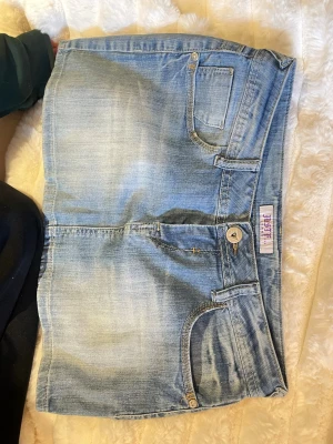 Lågmidjad jeanskjol - Lågmidjad jeanskjol i fint skick! Passar någon som har M. Midjemått: ca 40 cm                      Längd: 30 cm