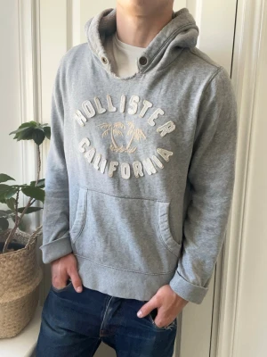 Hollister Cali hoodie  - Hollister Cali hoodie, lite stor på modellen. Inga defekter förutom ett hål i fickan! Modellen i bilderna är 180 cm 75 kg och bär Storlek M passar lite L , Kom med frågor! 🌟 (Kan gå ned i pris vid köp av paket 😉) 
