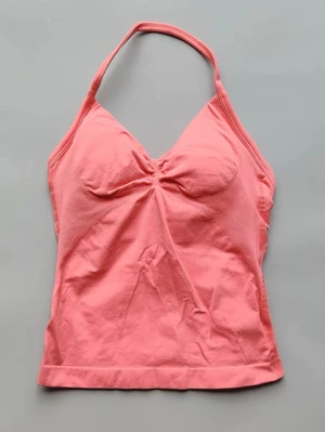 Rosa halterneck linnetopp - Snygg rosa linnetopp med halterneck och lätt rynkdetalj vid bysten. Toppen är ärmlös och har en feminin passform. . Tillverkad i mjukt bomullsmaterial som känns skönt mot huden. Passar som XS-S🥰