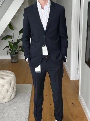 Tiger of Sweden kostym mörkblå  - Tjena säljer min Tiger of Sweden kostym som jag hade på avslutning och balen för 2 år sedan. Kostymen är endast använd en gång! Storleken är 50 på kavajen och 48 på byxorna. Ny pris är ca 6000kr mitt pris är 1500kr! Hör av er vid fler frågor eller bilder! Mvh 