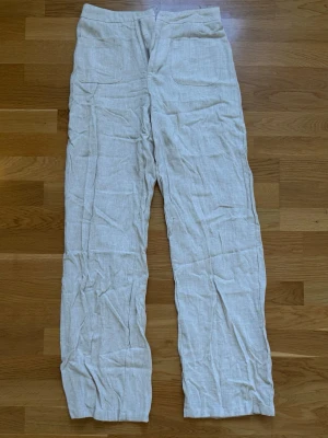 Beiga linnebyxor från SHEIN - Snygga beiga linnebyxor från SHEIN TALL i storlek S. Byxorna har raka ben, hög midja och två stora fickor framtill. Tillverkade i ett luftigt linnematerial som passar perfekt för varma dagar. Enkla att matcha med olika toppar för en chill look.