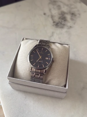 Klassisk silverklocka från Festina - Stilren klocka från Festina med rund mörkblå urtavla och silverfärgade detaljer. Armbandet är i blankt metall och har en klassisk länkdesign. Urtavlan har datumvisning och tydliga markeringar.     Klockan har små repor och är i använt skick.  Klockan skickas utan box. Batteriet hade behövts bytas kan göras innan försäljning vid överenskommelse, isåfall kostar den 199kr mer