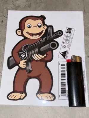 Nicke Nyfiken / Curious George Sticker 16x10cm - Säljer en kaxig och unik sticker föreställande Nicke Nyfiken med ett vapen. En rolig detalj som passar perfekt att klistra på bilen, epan, vapenskåpet eller varför inte i garaget? Märket är av hög kvalitet och tål att sitta uppe.  Mått: Ca 16 cm hög x 9,7 cm bred.  Detaljer: Se bilden med tändaren för storleksuppfattning