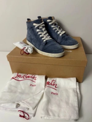 Blåa höga sneakers från Louboutin - Snygga blåa höga sneakers från Christian Louboutin i mocka med vita snören och vit sula. Klassisk siluett med diskret branding och lyxig känsla. Kommer med originalpåse och box. Perfekta för dig som vill sticka ut med stil.