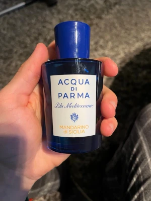 Acqua di Parma Mandarino di Sicilia - Fräsch parfym från Acqua di Parma, Blu Mediterraneo-serien. Flaskan är djupblå med vit etikett och blå text, och har en elegant, rund form. Doften Mandarino di Sicilia ger en citrusig och energisk känsla, perfekt för dig som gillar exklusiva och fräscha parfymer. 100 ml knappt använd max 2 ml