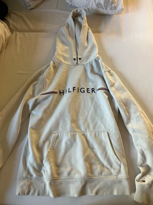 Vit hoodie från Tommy Hilfiger - En hoodie från Tommy hilfiger, den är i bra skick men saknar snören💗