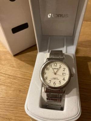 Seiko Lorus Lumibrite 50M 37mm Herrklocka - Säljer en snygg stilren herrklocka från japanska Lorus (Seiko) i nära nyskick enligt bilder. Enstaka tecken på användning som ej stör. Fungerar bra, originalarmband i rostfritt flexband/stål, datumvisare, mineralglas, japanskt urverk, vattentät, självlysande osv. Behöver bara nytt batteri. Fås i originalbox och förpackning.  Nypris: 1300 SEK Mitt pris: 489 SEK  Skickas snabbt och spårbart. Skriv vid frågor och se gärna mina andra annonser!   Tjocklek	9mm Artikelnummer	RS903BX-9 EAN-nummer	489