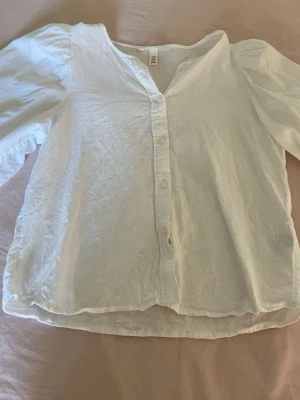Vit blus med puffärm från H&M - vit blus från H&M med puffiga trekvartsärmar och knappar framtill. Blusen har en avslappnad passform. Den är i storlek  xs