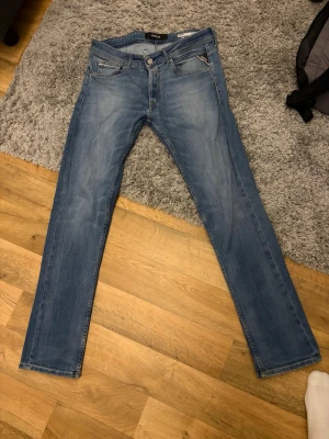 Replay jeans Grover - Snygga blå jeans från Replay, modell Grover. Klassisk femficksdesign med dragkedja och knapp. Jeansen har en rak passform och diskreta slitningar för en cool look. Perfekta till vardagsstilen och lätta att matcha med det mesta.