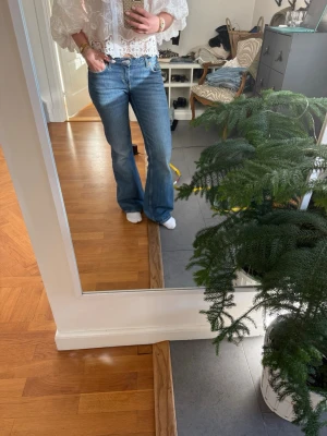 Blå bootcut jeans från weekday - Säljer ett par klassiska blå bootcut jeans från weekday med fyra fickor och normalhög midja. Jeansen har en snygg tvätt med lätt slitning och är tillverkade i denim. Perfekta för dig som gillar en avslappnad men trendig look.