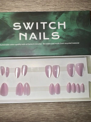 Switch Nails Pink Cat Eye Almond - Press-on naglar från Switch Nails i modellen Pink Cat Eye. Naglarna har en skimrande ljusrosa färg och kommer i formen Almond Short. Tillverkade av återvunnet material och kan återanvändas. Perfekt för dig som vill ha snygga naglar snabbt. Säljes utan tillbehör. Klisterrester i ena 4:an. 