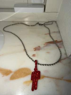Rött billie eilish halsband - Sätter ihop hemma själv. Halsbandet är 55 cm långt och blohshen är 4 cm. Den skimrar fint med röda stenar. Inspireras av billie eilish merch ❤️ Material rostfritt stål och zinc. 