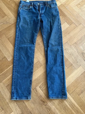 Levi's 502 blå raka jeans - Klassiska blå jeans från Levi's modell 502 med rak passform och fem fickor. Jeansen har normal midja och är tillverkade i slitstark denim med snygga kontrastsömmar. Perfekta för en avslappnad och tidlös stil. W 29 L32