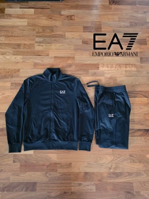 EA7 Tracksuit - Här är en version på cirka 500 tecken:  EA7 Emporio Armani Track Suit – Storlek M – Helt ny med tags Stilrent EA7-set i svart bestående av zip-jacka och matchande byxor. Minimalistisk och sportig design med diskreta EA7-loggor. Jacka med hel dragkedja, hög krage och sidofickor. Byxor med elastisk midja, snörning och smal passform. Perfekt för vardag, träning eller streetwear. Helt nytt med tags kvar. 📦 Snabb leverans – skickas samma dag (om ej hindr.) 📩 Kontakta vid frågor eller bilder.
