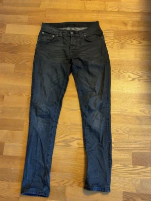 Nudie grim Tim  - Säljer ett par mörkgråa nudie. Modellen heter grim Tim som ni ser på 4e bilden. Skicket är bra utan defekter. Modellen på bild 5 är 180 och väger 65. Skriv för mer frågor.