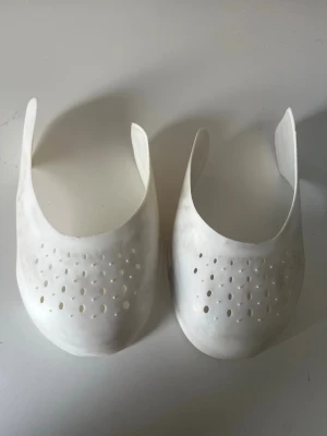 Vita skoinlägg för tåbox - Säljer ett par vita skoinlägg i plast som används för att hålla formen på tåboxen i sneakers eller andra skor. Inläggen har perforerade hål för ventilation och är formade för att passa de flesta skomodeller. Perfekt för dig som vill undvika veck på skorna. Vid frågor skriv till mig och priset kan diskuteras 