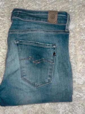 Replay jeans  - Säljer ett par blå Replay jeans. OBS jeansen har ett hål på ena knät. Midja 36cm, längd 99cm. JAG SKICKAR EJ FLER BILDER NÄR JAG BÄR JEANSEN! för bättre inblick i passformen rekommenderar jag att googla på modellnamnet. För storleksguide kolla måtten noggrant då jeansen alltid kan vara uppsydda heller krympta och jag ej tar emot returer :) s6,1