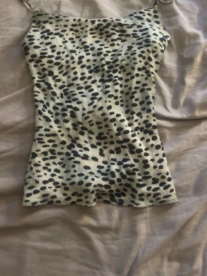 Leopardmönstrad linnetopp från Zara - Säljer en slutsåld snygg leopardmönstrad linnetopp från Zara i ljusa toner. Toppen har tunna axelband och är figurnära. 