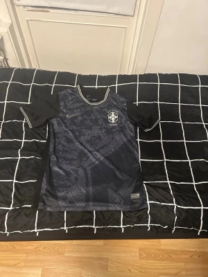 Nike Brasilien fotbollströja – Storlek S – Nästan ny - Säljer en stilren Nike Brasilien fotbollströja i storlek S. Tröjan är i mycket bra skick och endast använd 2–3 gånger.  ✔️ Original Nike (Dri-FIT) ✔️ Bekväm och lätt – perfekt för både träning och vardag ✔️ Snygg svart design med Brasilien-emblem  Obs: Det finns en liten defekt baktill (se bild), men inget som påverkar användningen.   Pris: Kan diskuteras 📦 Skickas samma dag vid snabb affär  Hör av dig vid frågor eller intresse! 👍