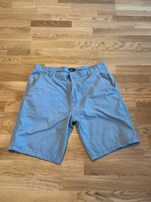 Shorts storlek XL - Ljusblå shorts med sidofickor fram, två bakfickor med knapp och hällor för bälte. Från Lager 157, storlek XL.