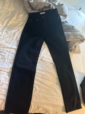 Svarta raka jeans från Weekday - Säljer ett par svarta jeans från Weekday med rak passform och hög midja. Klassisk femficksmodell och stilren look som passar till det mesta. Materialet är kraftigt denim i bomull. Perfekta för dig som gillar en clean och enkel stil. Nypris 599:- oanvända 