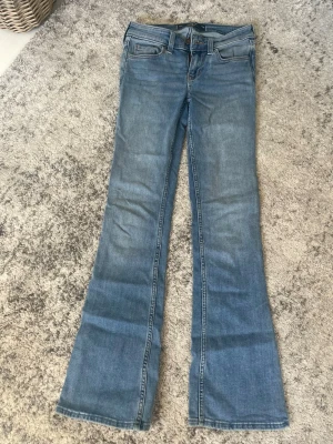 Blå lågmidjade bootcut jeans  - Säljer ett par lågmidjade bootcut jeans med snygga sömmar på bakfickorna. 