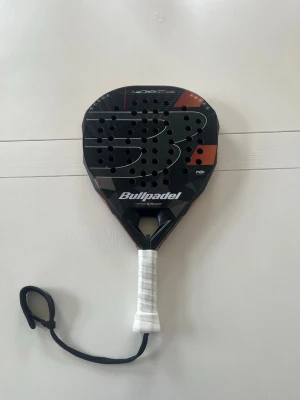 Padelrack från Bullpadel - Säljer mitt padelrack från Bullpadel som jag har använt nu ett tag. Racket funkar hur bra som helst även fast det har två skador på sidorna.              Hör av dig vi frågor eller funderingar.
