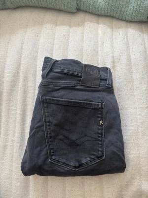 Svarta Replay jeans med raka ben - Snygga svarta jeans från Replay med raka ben och klassisk femficksmodell. Jeansen har detaljerade sömmar på bakfickan och Replay-logga på både knapp och etikett. Tillverkade i mjukt denimtyg som ger en skön passform och stilren look.