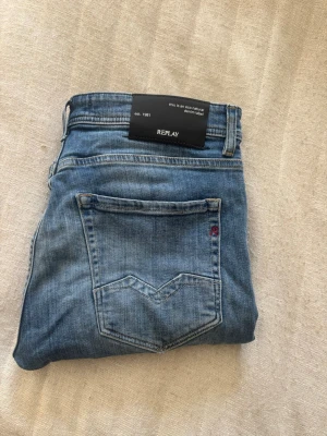 Blå jeans från Replay - Snygga blå jeans från Replay med klassisk femficksmodell och diskret tvättad look. Jeansen har normal midja, raka ben och detaljerade sömmar på bakfickan. Materialet är mjukt denim som ger en bekväm känsla och passar till många olika stilar.