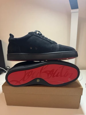 Svarta sneakers från Christian Louboutin - Säljer ett par svarta skor från Christian Louboutin med klassisk röd sula och diskret logga på hälen. Skorna är i storlek 42 och är jävligt feta. Priset är ej hugget i sten så kom gärna med bud!. ⚠️SKORNA ÄR EJ ÄKTA⚠️
