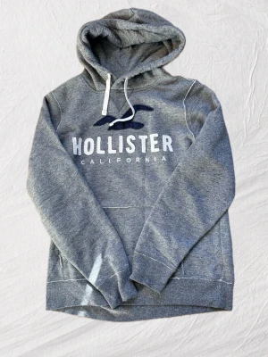 Hollister hoodie M - Säljer en riktigt schysst grå hollister hoodie i storleken M. ✨ Tröjan har inga defekter - inga fläckar - inga hål - ingen dålig lukt ( kommer från djur och rökfritt hem🚭🐾) Tröjan är nyskick, då den knappt är använd✨🌟  Gåvor medföljer vid köp utan bud🎁💝  Tveka inte att ställa frågor vid minsta funderingar💬