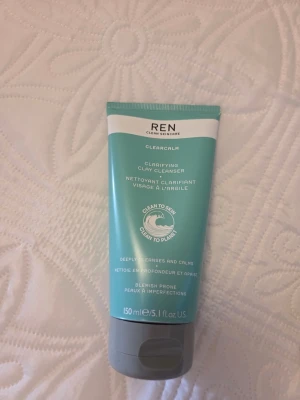 REN Clarifying Clay Cleanser 150 ml - REN Clarifying Clay Cleanser är en ansiktsrengöring i en turkos och vit tub med grått lock. Produkten är framtagen för att djuprengöra och lugna huden, speciellt för hud med benägenhet för blemmor. Tuben rymmer 150 ml och är tillverkad i plast. Endast testad.