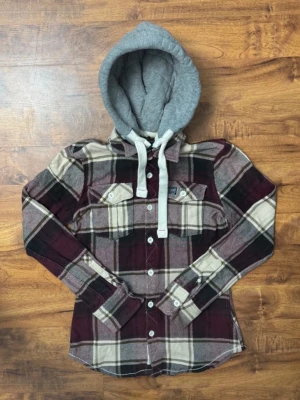 Superdry overshirt  - Snygg overshirt av märket Superdry i vinrött, beige och svart rutmönster med två bröstfickor och vita knappar. Har en grå huva. Pris är diskuterbart⁉️