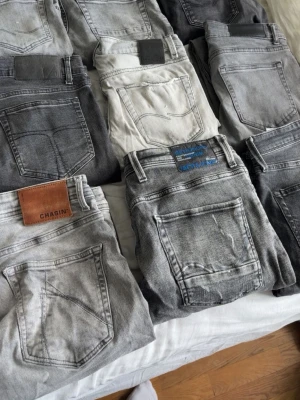 jeans bundel - Säljer ett gäng snygga jeans i olika grå och svarta nyanser, vissa med slitningar och tvättade effekter. Några har läderpatch med logga, för mer info kolla in min profil för mer info på Jeansen