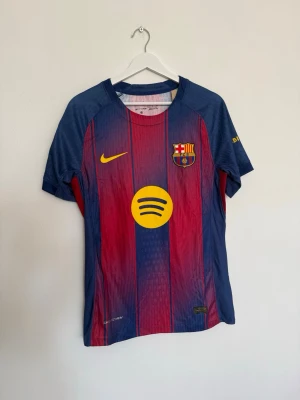 Barcelona matchtröja Nike Rashford 14 - Säljer en FC Barcelona matchtröja från Nike i blått och rött med gula detaljer. Tröjan har klubbmärke, Nike-logga och Spotify som sponsor framtill samt Rashford och nummer 14 på ryggen. Korta ärmar och Champions League-märke på ärmen.
