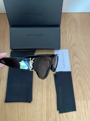 Svarta Saint Laurent solglasögon - Säljer dessa snygga svarta solglasögon från Saint Laurent. Kommer med allt ni ser på bilderna✨
