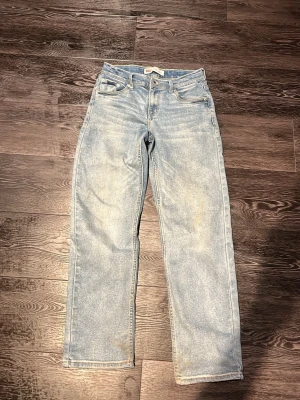 Levis jeans - Säljer ett par ljusblå jeans med rak passform och klassisk femficksdesign. Jeansen har hög midja och är tillverkade i ett slitstarkt denimtyg. Perfekta för en avslappnad och trendig look.