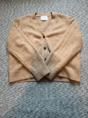 Beige stickad kofta  - Fin och mysig stickad kofta i storlek 152, använd fåtals gången och den känns helt ny i materialet 