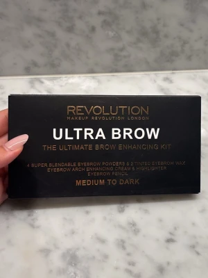 Ultra Brow Kit Medium to Dark - Ultra Brow Kit från Makeup Revolution i färgen Medium to Dark. Innehåller flera nyanser av brynpuder, vax, highlighter, brynpenna och pincett. Perfekt för att forma och fylla i ögonbrynen. Har sålts för 145 kr på Lyko 🩷