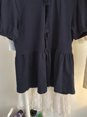 Mörkblå blus med knyt och puffärm - Säljer en mörkblå blus med puffärmar och knyt framtill. Blusen har en lös passform och volang nedtill som ger en söt och avslappnad look. Perfekt att styla med jeans eller kjol för en trendig outfit.