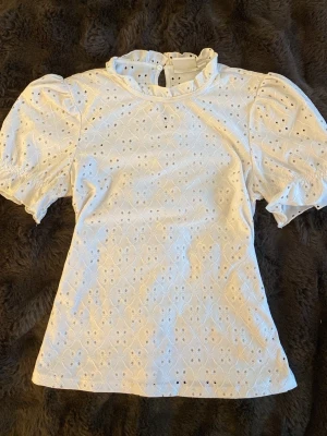 Vit broderad blus med puffärm - Söt vit blus i broderad bomull med puffiga korta ärmar och volangdetalj vid änden. Perfekt för dig som gillar en feminin och trendig stil. Strl XS men passar S. Pris kan diskuteras!❤️