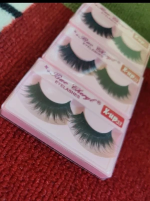 Bao Cheryl lösögonfransar (ink lim) - Säljer tre par Bao Cheryl lösögonfransar i modellen X-up33. Fransarna är svarta, täta och har en dramatisk, fluffig form som ger volym och längd. Förpackade i rosa askar. Perfekta för att lyfta din ögonmakeup.  Inkluderar ett lim samt 3 fransar totalt.