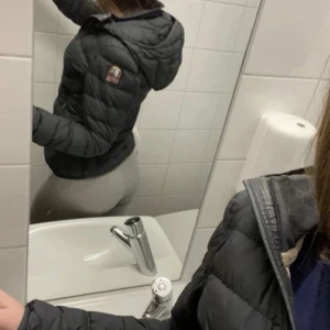 Svart pufferjacka med huva - Snygg svart para jumper jacka med huva och quiltad design. Jackan har en patch på ärmen och dragkedja framtill. Perfekt för kalla dagar och ger en sportig look. Passar dig som vill ha en varm och trendig jacka till våren 