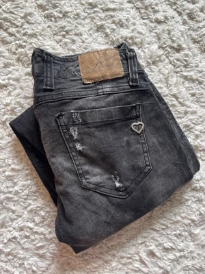 Svarta slitna jeans med hjärtdetalj - Mått: Midja: 37cm, Innerbenslängd: 78cm 💕 Hör av dig vid frågor 