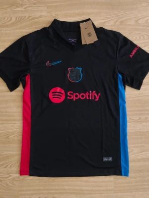 Svart FC Barcelona matchtröja Nike - Snygg svart FC Barcelona matchtröja från Nike med klubbmärke och Spotify-logga på bröstet. Storlek S 160-170 cm