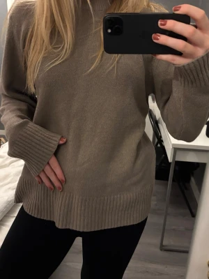 Beige stickad polotröja - Mysig beige stickad polotröja med långa ärmar och breda ribbade muddar vid ärmslut och nederkant. Såååå mysigt material!